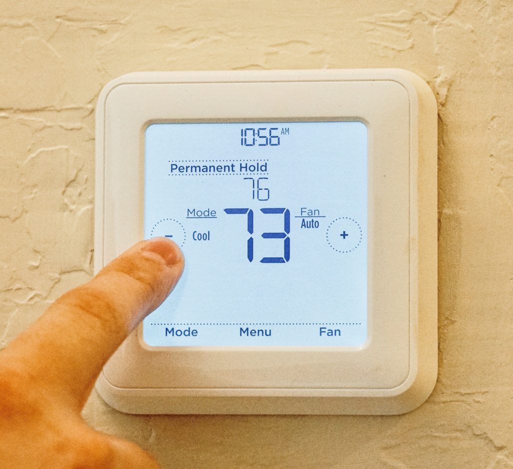 Closeup of an adult male finger adjusting the temperature on a thermostat
